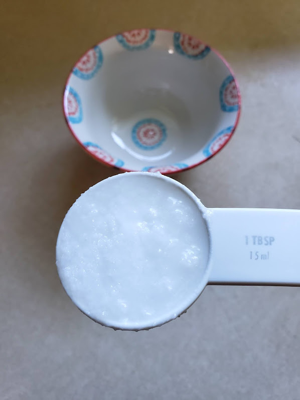 Coconut oil in measuring spoon