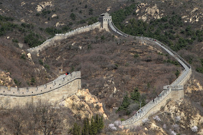 Visitors walk along the Badaling section of the Great Wall of China, some 70 kilometres north of Beijing on April 11, 2012. The Great Wall of China is a series of fortifications made of stone, brick, tamped earth, wood, and other materials generally built along an east-to-west line across the historical northern borders of China in part to protect the Chinese Empire against intrusions by various nomadic groups or military incursions.