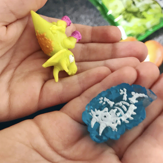 Mini fossil and dino laid out in a child's hands