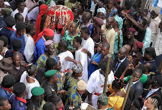 Sangosakin close to the arugba, the carrier of the sacred calabash (hidden under the red cloth) at the annual procession, bringing Oshun Oshogbo to the river
