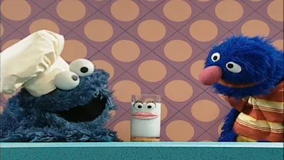 Cookie Monster prepares a glass of milk as a healthy snack to Grover. Sesame Street Happy Healthy Monsters