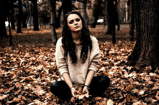 Girl-sitting-alone-in-the-leaves