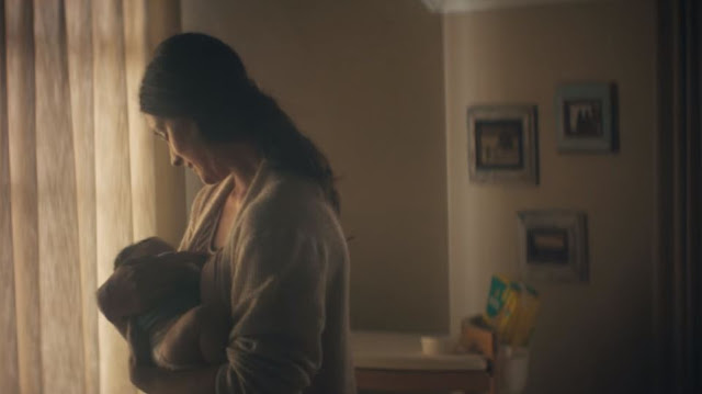 A mother singing a lullaby to a newborn baby to comfort them as part of the Pampers #BetterForBaby Campaign