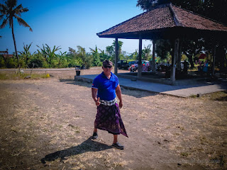 Pecalang Balinese Local Security Officer walking around under the sunlight before the cremation ceremony begins