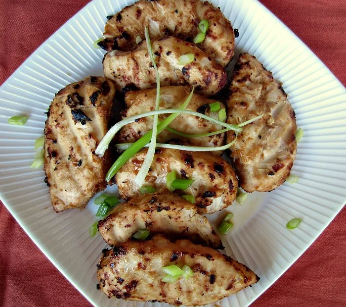Grilled Peanut Ginger Chicken by Renee's Kitchen Adventures on a white plate garnished with green onion