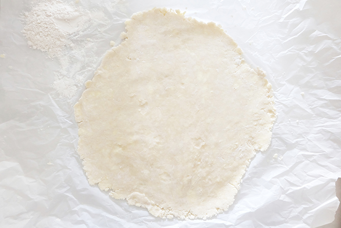 rolled out piece of pie dough on parchment