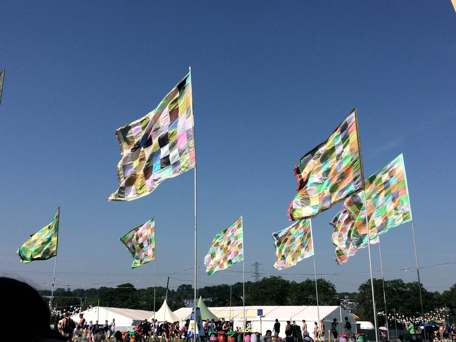 Flags waving in blue sky at Glastonbury Festival 2017