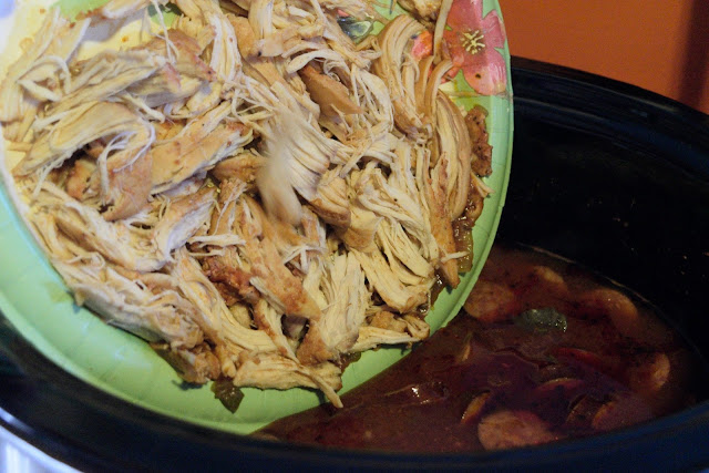 The shredded chicken being returned to the crockpot. 