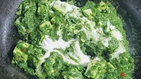 Cooking palak paneer with adding cream for Palak Paneer recipe