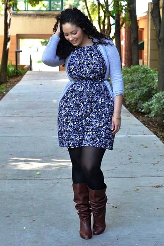 Plus size woman wearing floral dress, black tights and brown boots