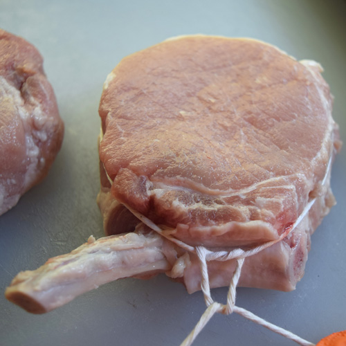 Tying a frenched Cheshire Heritage pork rib chop using a surgeons knot with kitchen twine.