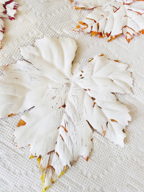 white painted fabric leaf on paper towel getting paint dry.