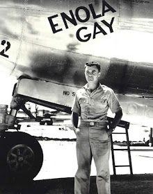 Paul Tibbets standing in front of his bomber named Enola Gay worldwartwo.filminspector.com