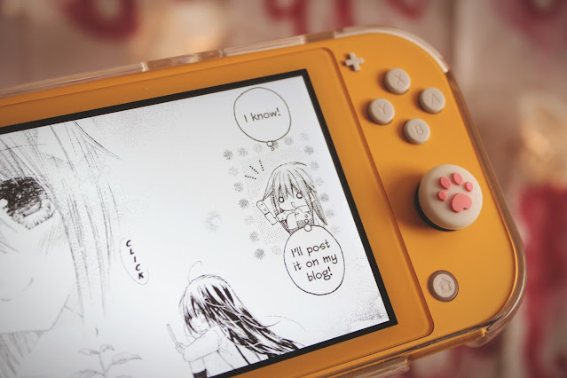 A Nintendo Switch Lite shows a manga panel in which a girl says, "I know", and then, "I'll post it on my blog".