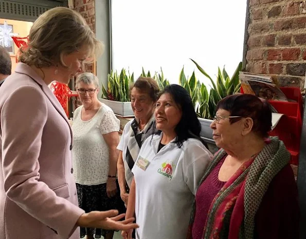 Queen Mathilde wore a light pink top and matching long jacket/coat, combined with grey pants, pink stone earrings at Buurtwerk Chambéry association in Laag Etterbeek