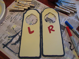 two bedroom door hangers. One has a red letter "L" and the other has a red letter "R".