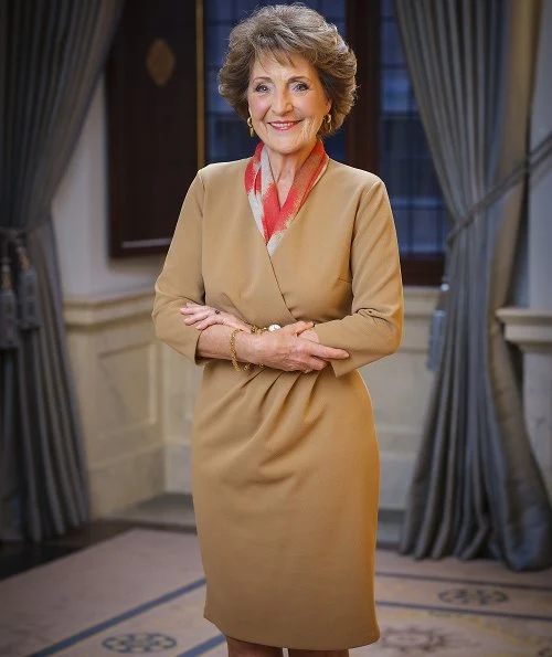 Princess Margriet wore a camel silk dress and red print scarf from Armani. green emeralds with white diamond earrings