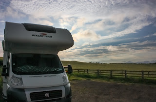 Photo of our motorhome at the edge of the car park with beautiful rolling hills behind.