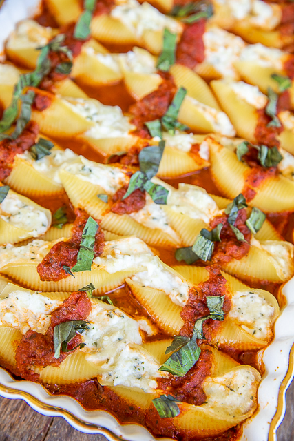 Million Dollar Stuffed Shells - hands down the BEST stuffed shells EVER! Jumbo shells stuffed with cottage cheese, cream cheese, sour cream, parsley, and mozzarella cheese. Bake in a quick meat sauce made with Italian sauce and jarred spaghetti sauce. Can make in advance and refrigerate or freeze for later. #pasta #casserole #italian #freezermeal baked stuffed shells in baking dish