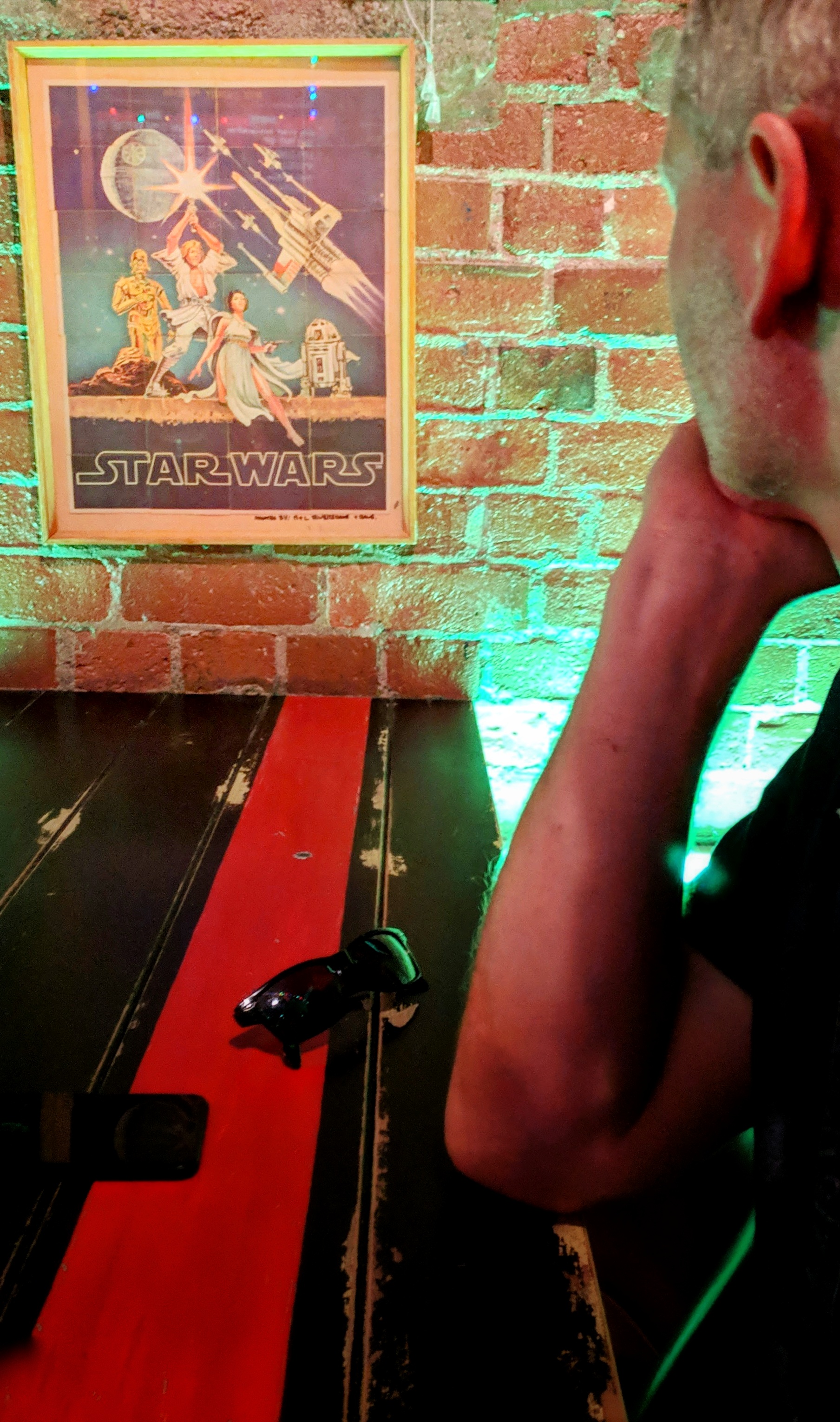 Man looks at Star Wars card poster in a bar