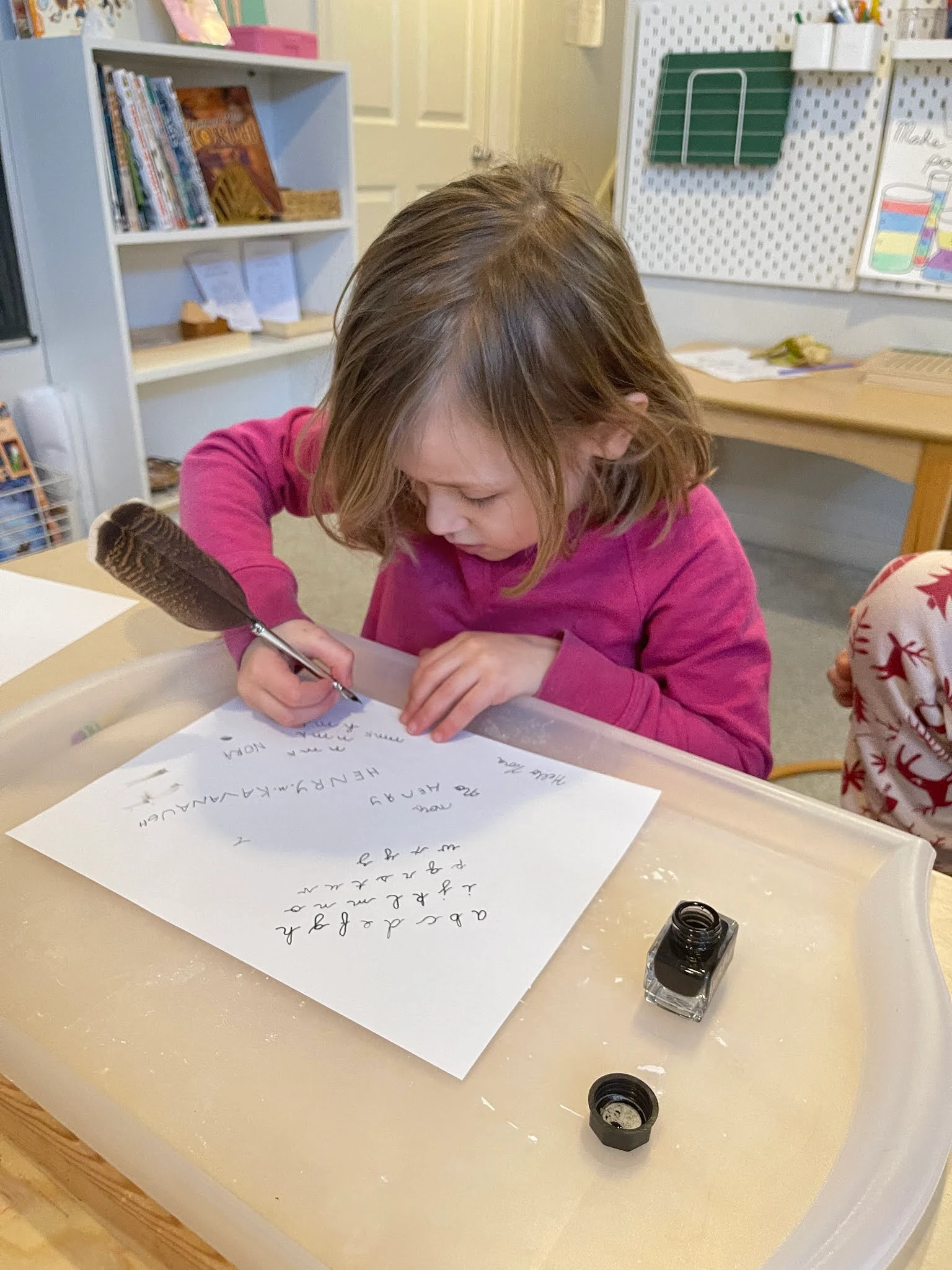 Montessori elementary child explores writing with a quill after the fourth great Montessori lesson.