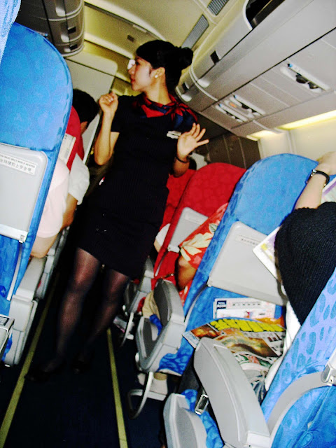 stewardess in aisle of aeroplane