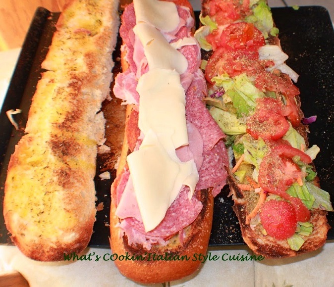this is a classic antipasto inside a loaf of bread made into a submarine sandwich
