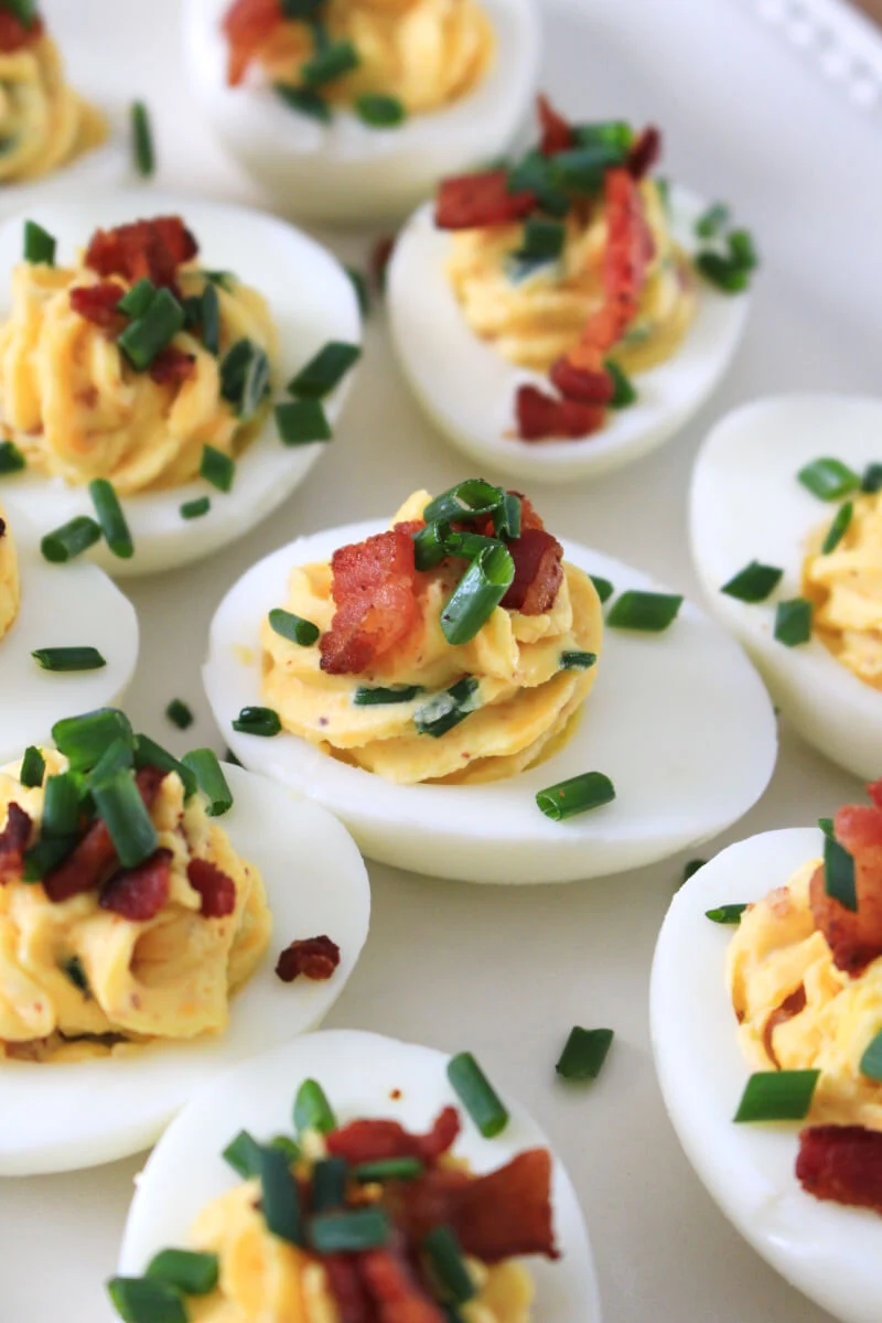 Loaded Deviled Eggs are fully loaded with cheddar cheese, bacon, chives, and horseradish mustard. You will want to serve them at every holiday and party! #appetizer #deviledeggs