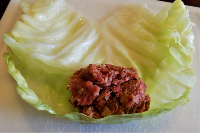 A picture of stuffing sitting on a cabbage leaf ready to roll