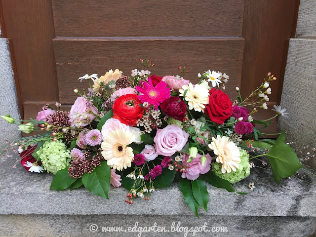 Blumenarrangement mit Gerbera, Rosen und Wachsblumen