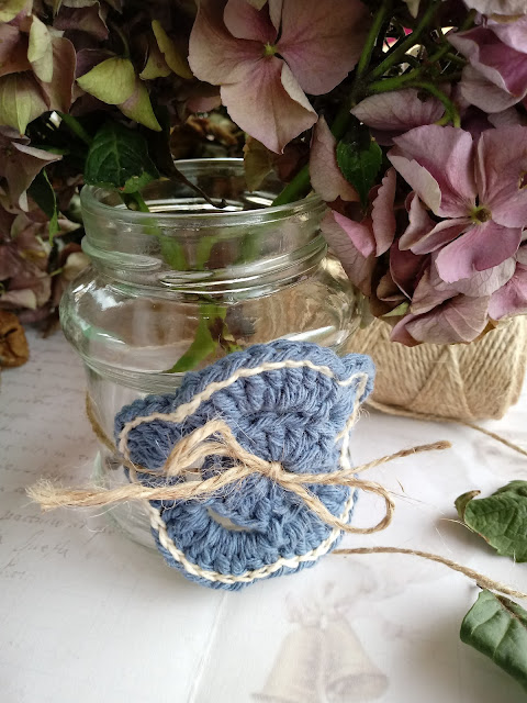 Bote de cristal decorado con flor de ganchillo azul y con hortensias secas