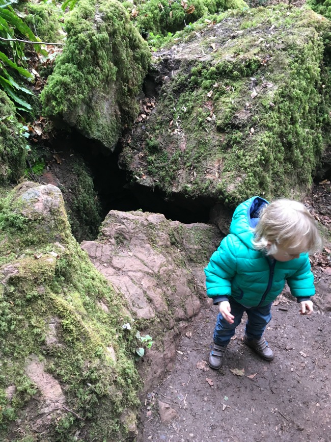 toddler stood by hole in rock