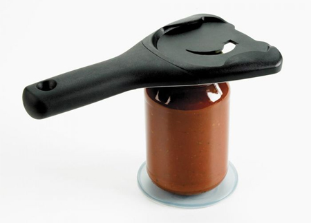 promotional image of the jar opener atop a jar of sauce, which is sitting on a round pad