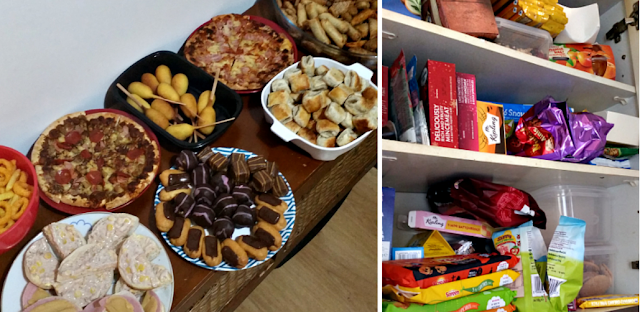 A table full of party food and a kitchen cupboard in need of a clear out.