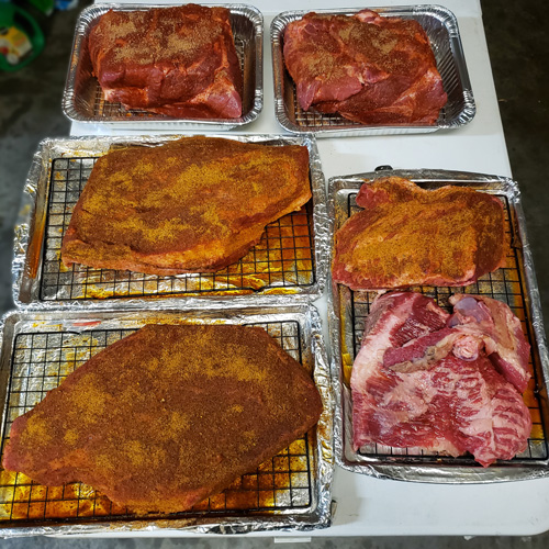 Briskets and pork butts prepped for the smoker