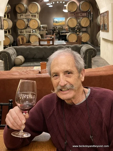 winery owner Robert Rex holding a glass of 2012 Syrah Cuvee in cave tasting room at Deerfield Ranch Winery in Kenwood, California