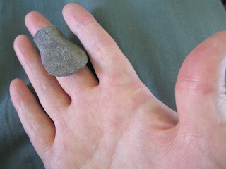 elongated piece of grey suede leather covering right middle finger from above the top joint to below the middle joint