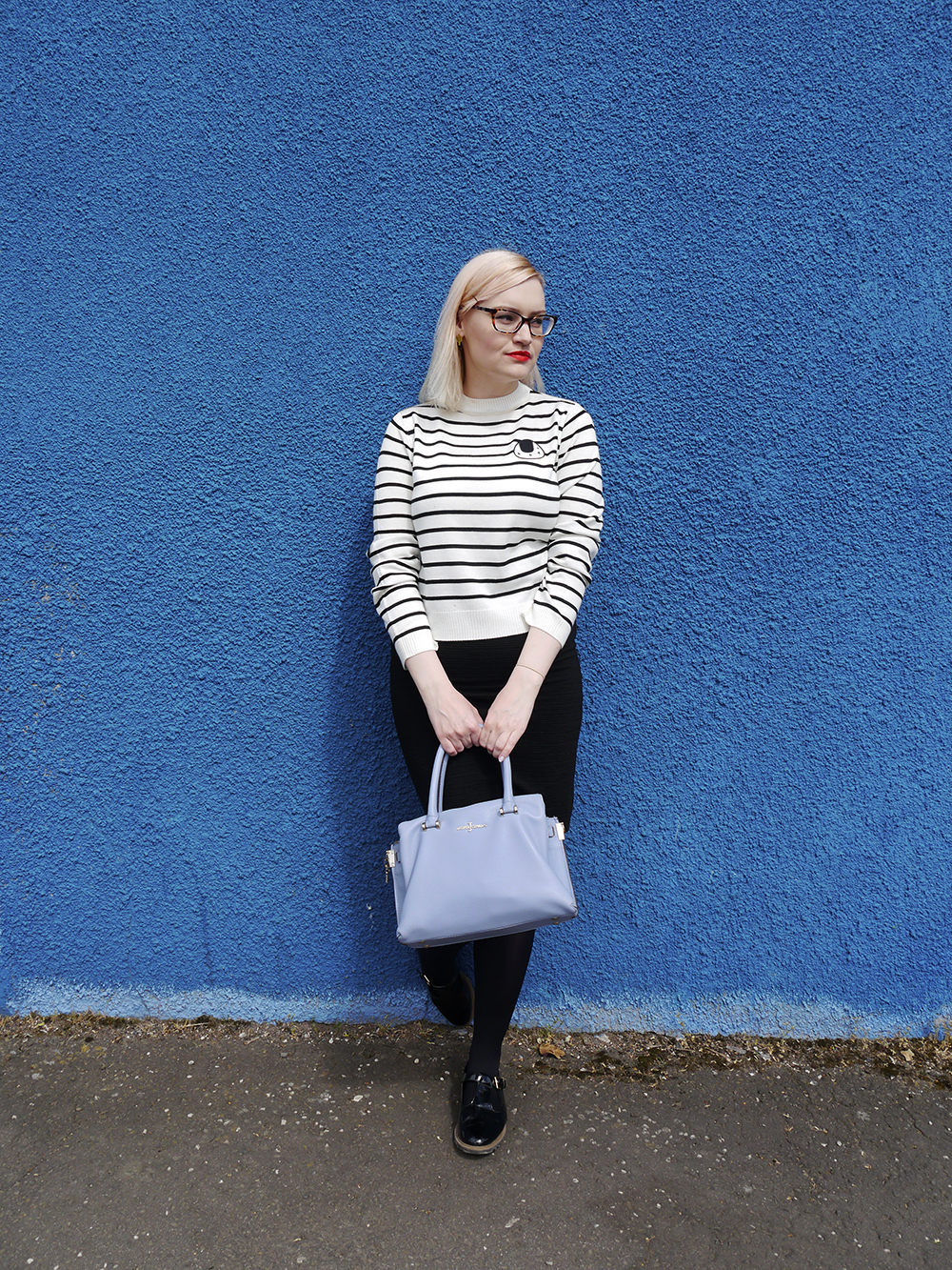 Scottish fashion blogger Kimberley Grahame from Wardrobe Conversations wearing The Whitepepper sushi striped top and monochrome outfit Scottish fashion blogger, Wardrobe Conversations, Jasper Conran bag from Debenhams, blue background, monochrome outfit inspiration, The Whitepepper top, sushi print, ScotStreetStyle Dundee location, Dundee style blogger