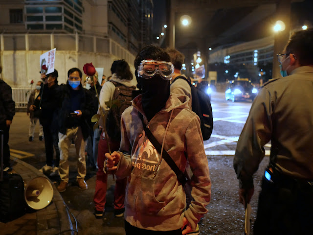 person holding a rose and wearing a face mask and goggles