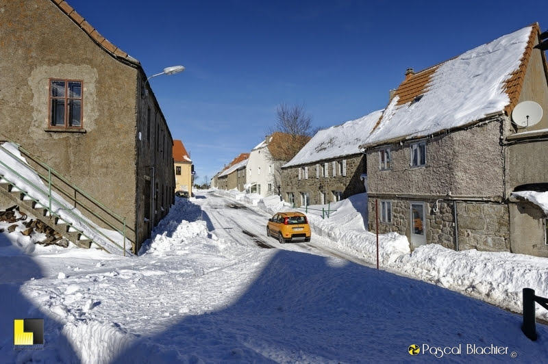 une voiture traverse le village dans la neige photo Pascal Blachier