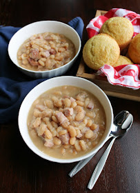 Make ham and beans in your instant pot for a satisfying meal. It's a great way to use leftover ham and there's no need to soak the beans! bowls of ham and beans next to basket of corn muffin