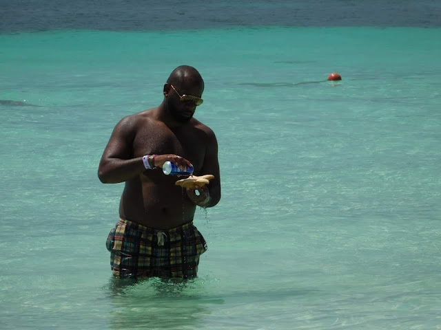 Turista jugando con una estrella de mar presuntamente real en Isla Mujeres