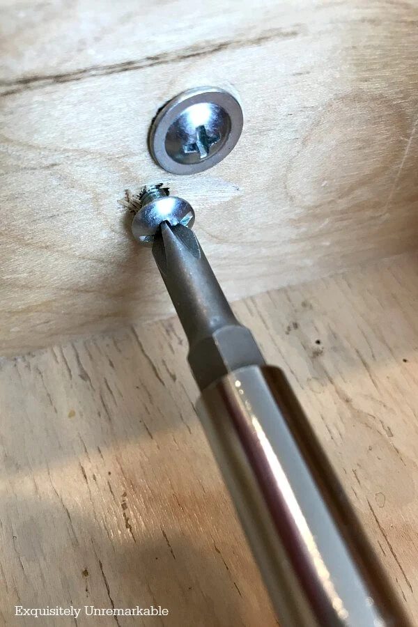 A Screwdriver Unscrewing Kitchen Cup Pulls Inside A Drawer