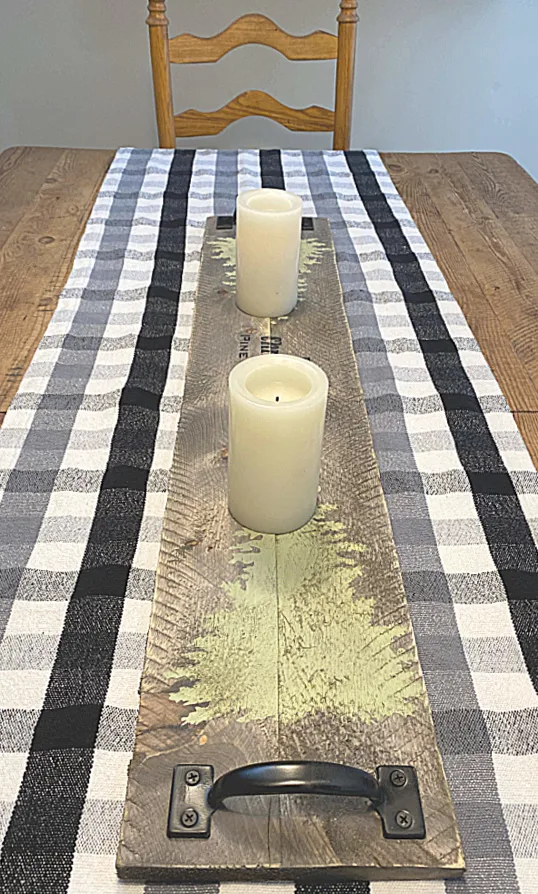 Wooden table runner on a farmhouse table with a buffalo check runner
