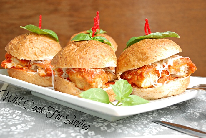 4 Chicken Parmesan Sliders on a white plate with red sword toothpick