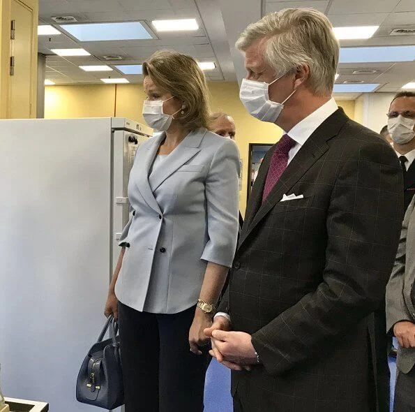 Queen Mathilde wore a blue double-breasted blazer by Emporio Armani. Queen carries Armani bag. Meghan Markle