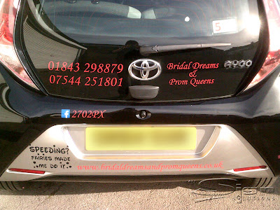 The back of Bridal Dreams & Prom Queens car featuring the website address, phone numbers, facebook url and logo.
