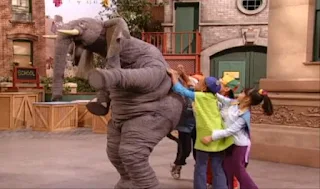 The students scratch the elephant's back. Sesame Street Episode 4071, Professor Super Grover's School for Superheroes