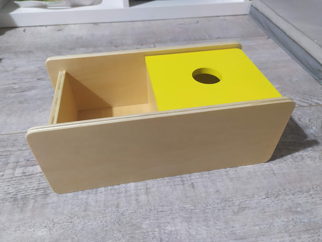 Nido Montessori : Boîte à couvercle basculant avec balle en laine (8-9 mois)