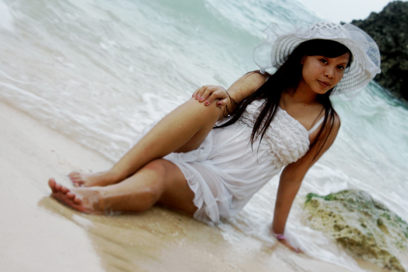 Model cewek Igo Gaun putih main air di pantai